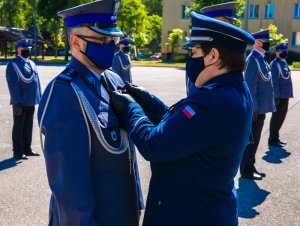 Komendant CSP przypina odznakę Zasłużony Policjant