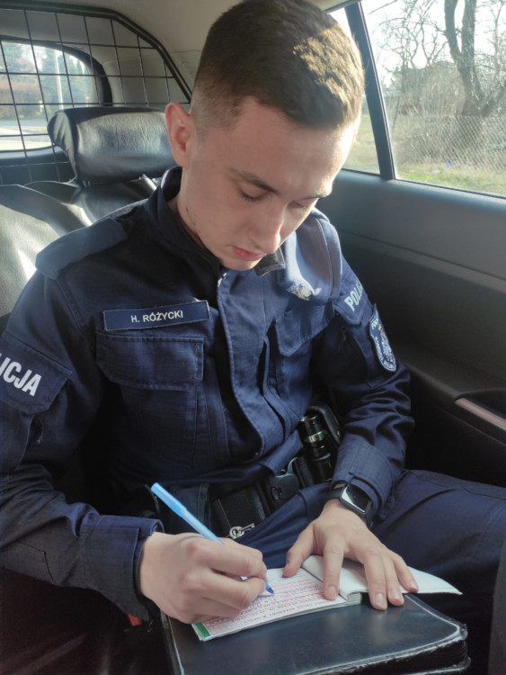 Policjant podczas sporządzania dokumentacji w notatniku służbowym