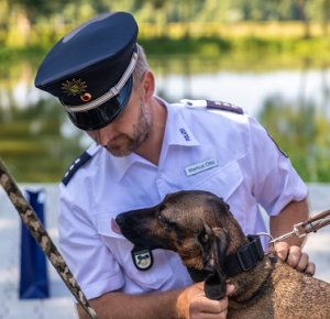 Zdjęcie przedstawia funkcjonariusza niemieckiej Policji z psem